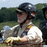 Two individuals on a motorcycle wearing helmets and jackets